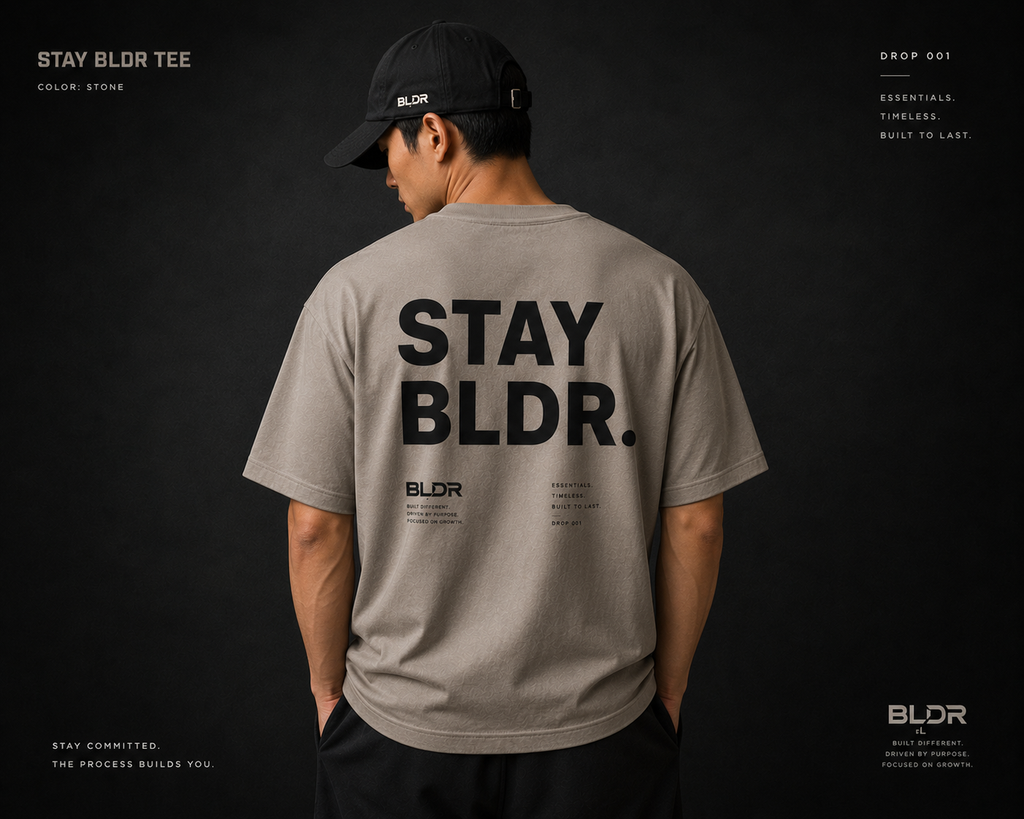 Person wearing a gray 'STAY BLDR' t-shirt with branding on a dark background