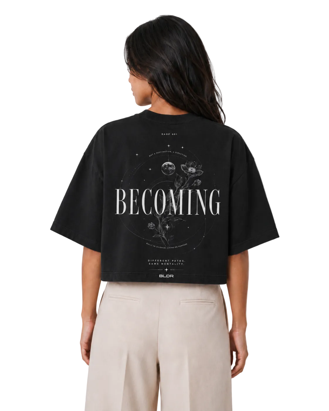 Person wearing a black t-shirt with 'BECOMING' printed on the back against a plain background