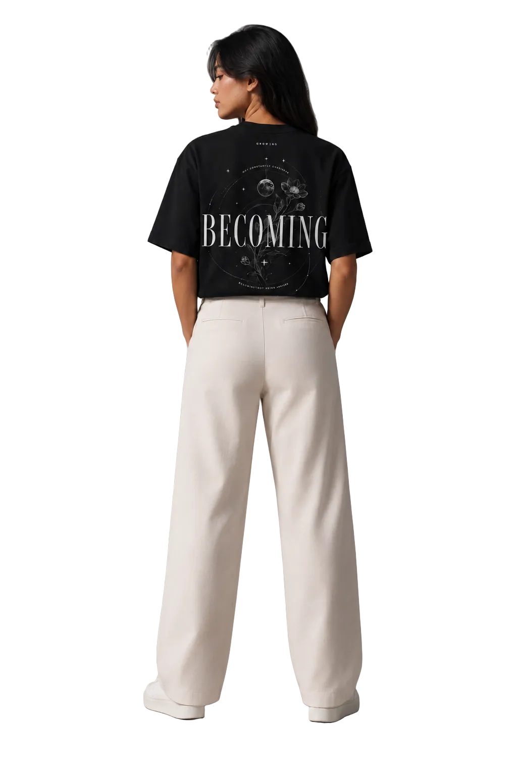 Person wearing a black t-shirt with 'BECOMING' text on the back, standing against a gray background.