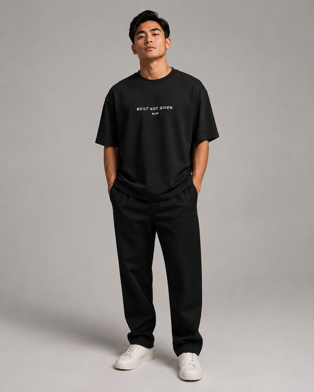 Man wearing a black t-shirt and pants with text on a gray background
