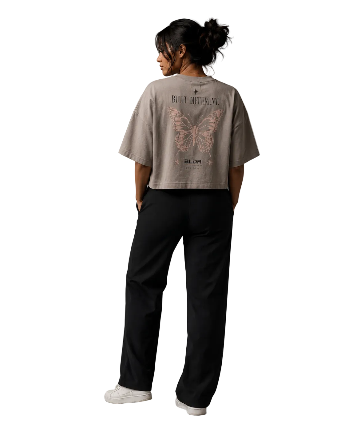 Person wearing a gray t-shirt with butterfly design and text, standing against a plain background