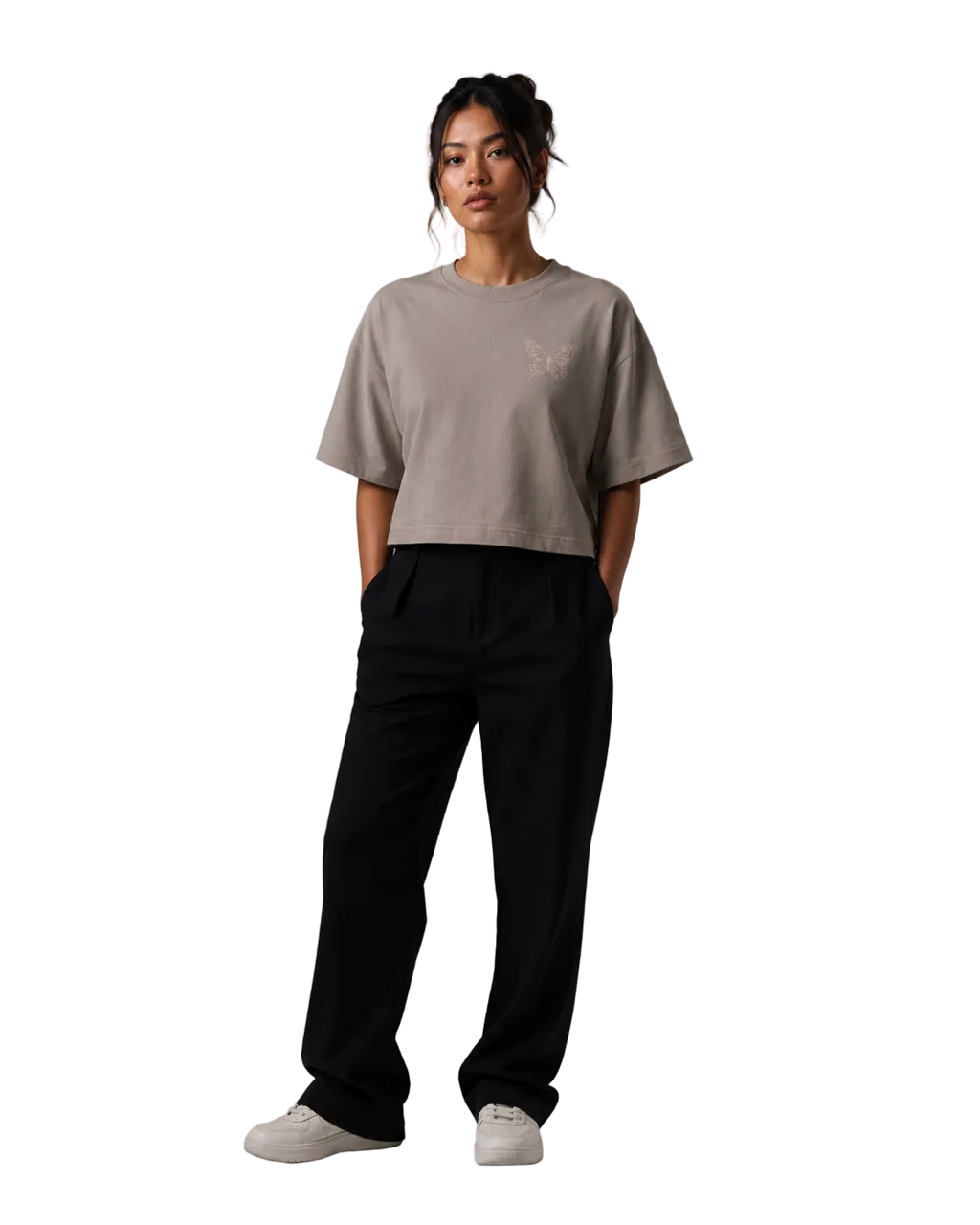 Person wearing a beige t-shirt and black pants on a gray background